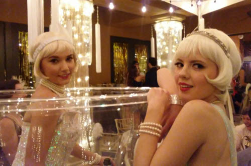 New Years Eve entertainers, two girls in beaded costumes in a giant champagne glass